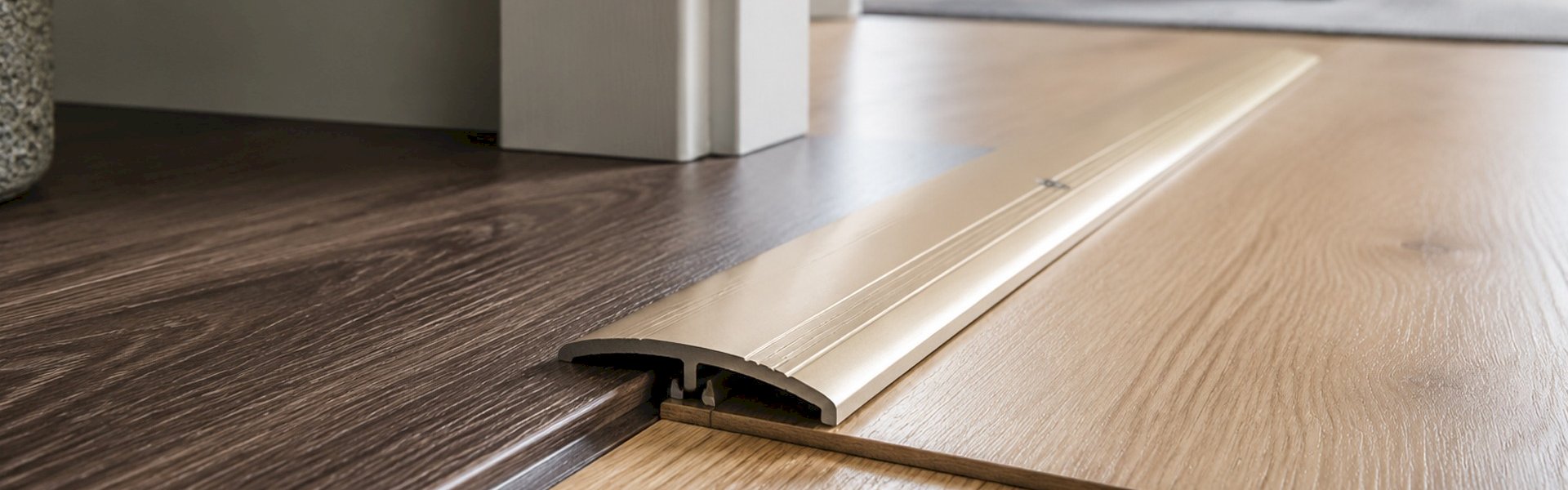 Wood effect laminate flooring threshold strip creating a smooth room-to-room floor transition